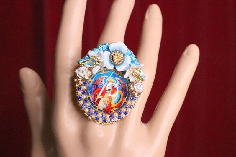 A hand wearing a ring with a picture of jesus.