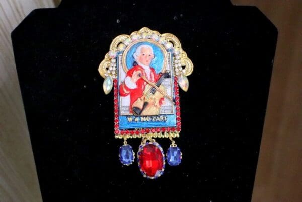 A brooch with a picture of a man playing the guitar.