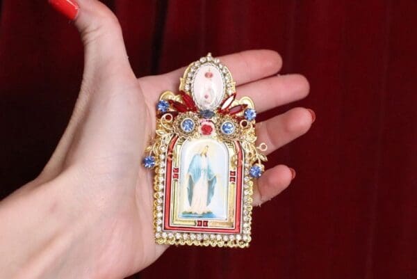 A person holding onto a small picture of jesus