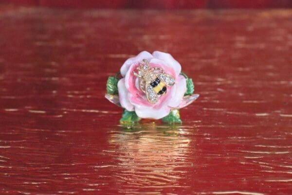 A pink flower sitting on top of a wooden table.