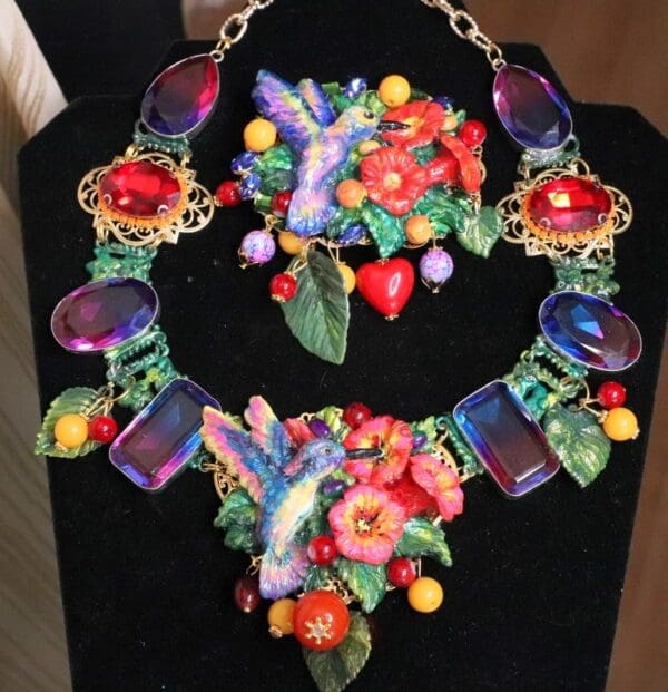 A necklace and bracelet set with flowers, leaves and butterflies.