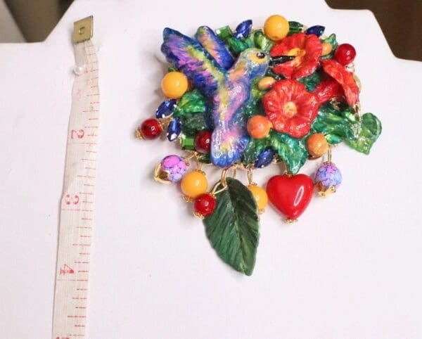 A white table with a large scale ruler and some colorful flowers