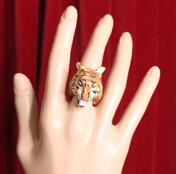 A hand with a tiger ring on it