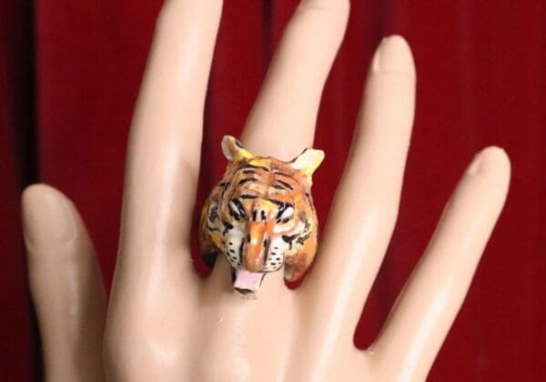 A hand with a tiger ring on it