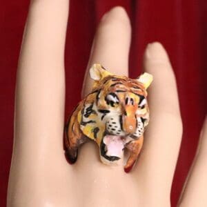 A hand with a tiger ring on it
