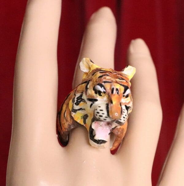 A hand with a tiger ring on it