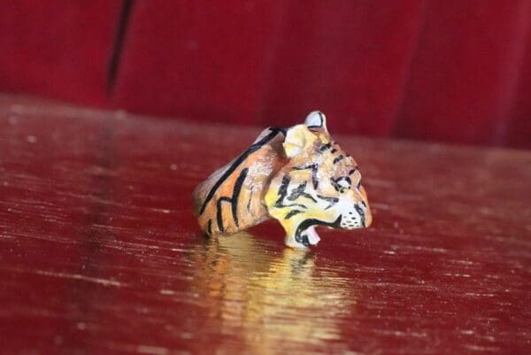A tiger figurine sitting on top of a wooden table.