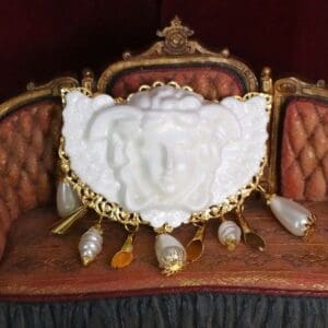 A white statue sitting on top of a brown couch.
