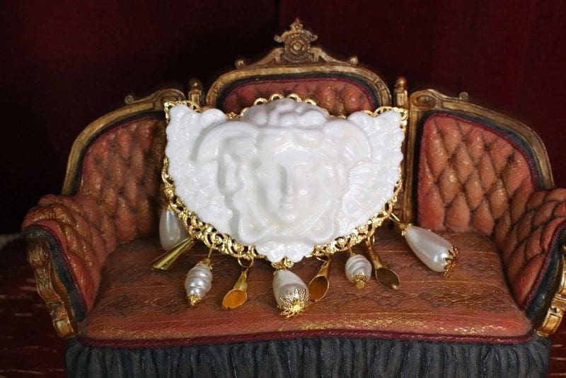 A white statue sitting on top of a brown couch.