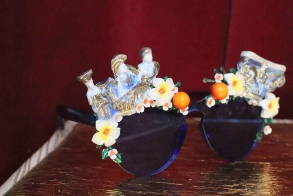 A pair of hats with flowers and oranges on them.