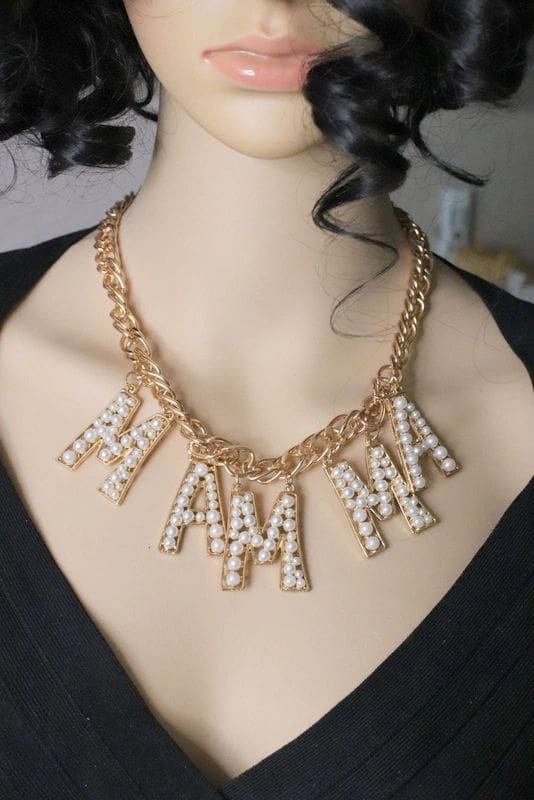 A woman wearing a necklace with the letters mama on it.
