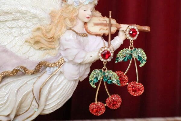A close up of a doll with cherries on it