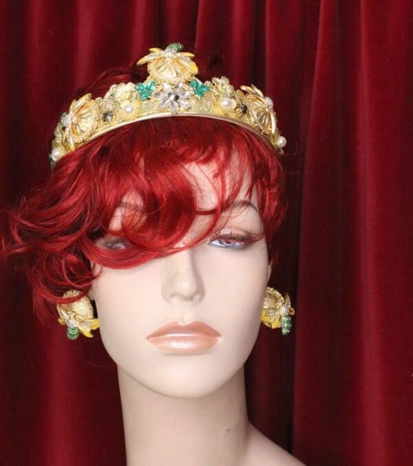 A mannequin wearing a crown and red wig.