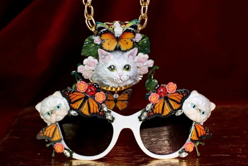 A necklace and sunglasses with butterflies on them.