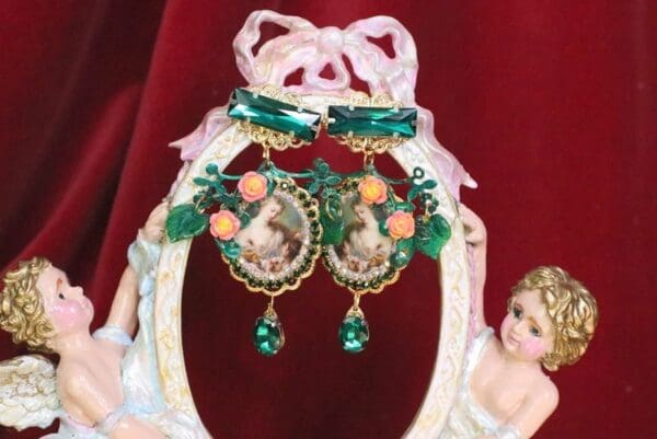 A pair of earrings with a picture and bells.