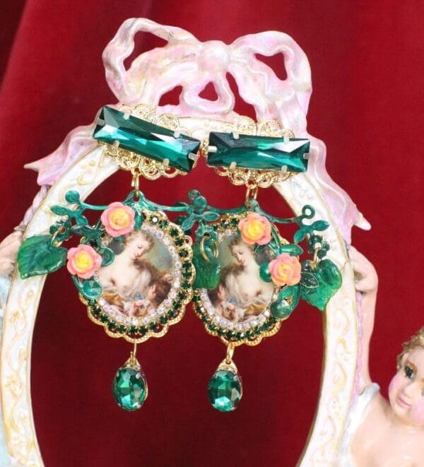 A pair of earrings with green and orange decorations.