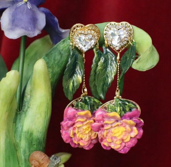 A pair of earrings with flowers and leaves.