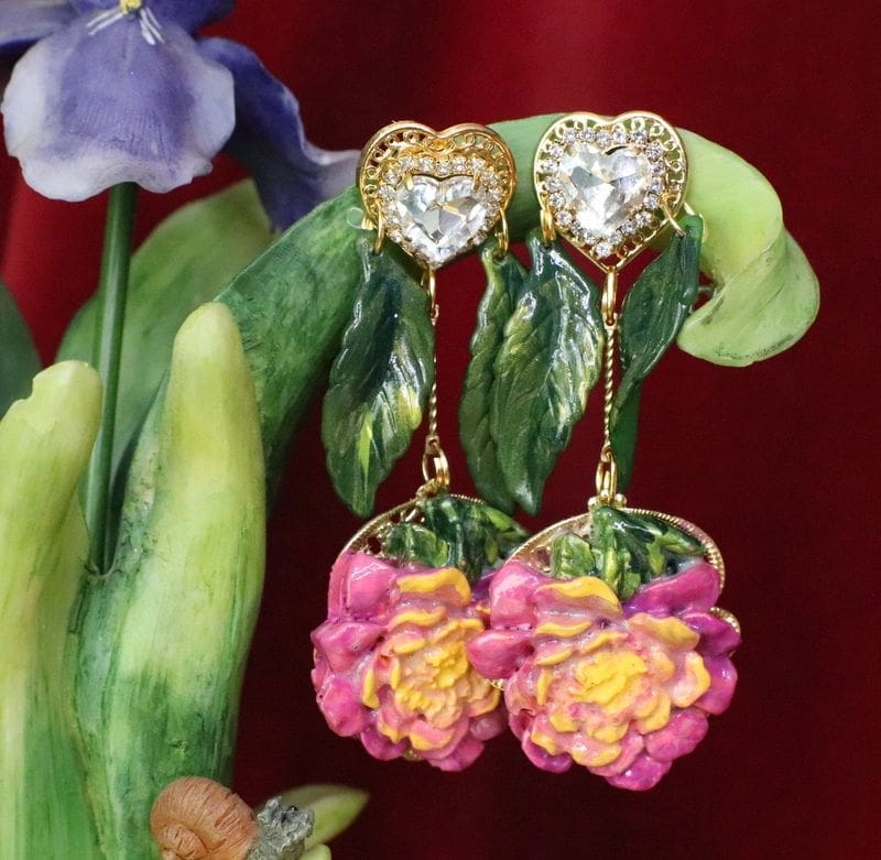 A pair of earrings with flowers and leaves.