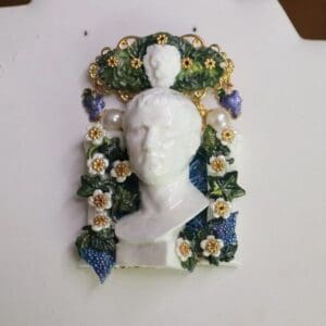 A white bust with flowers and leaves on it.