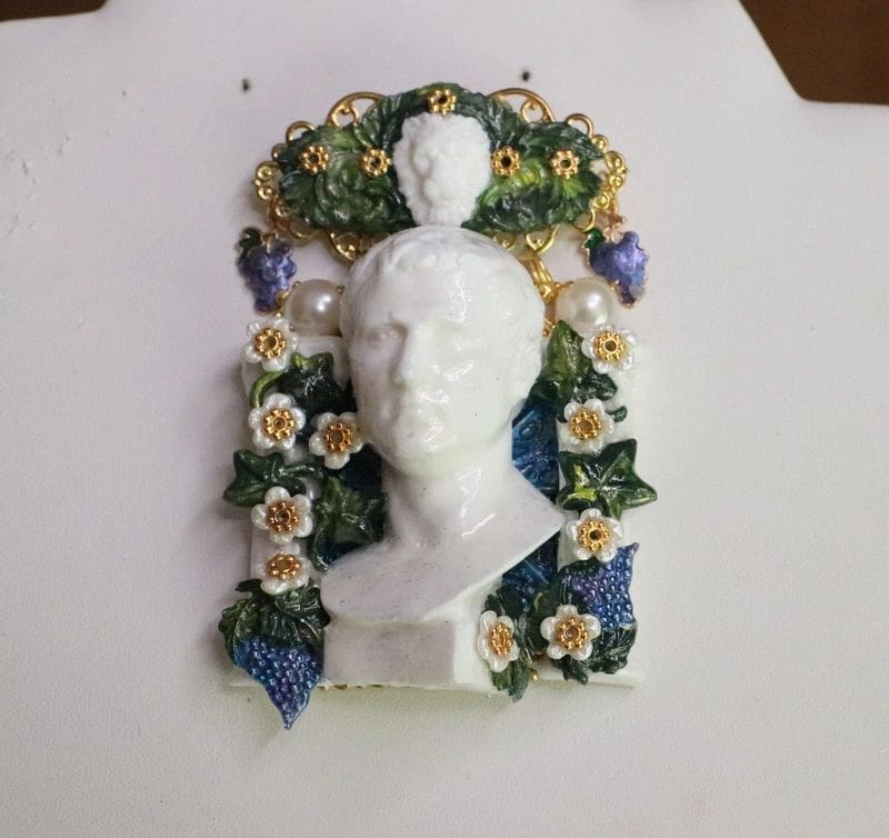 A white bust with flowers and leaves on it.