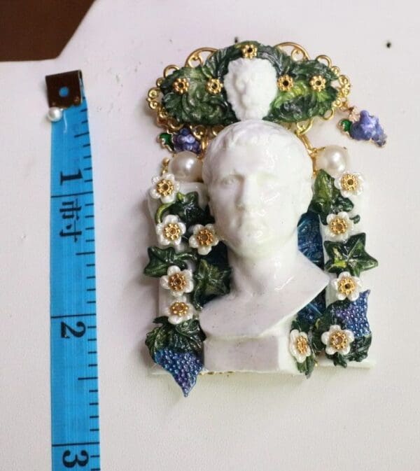 A white statue with flowers and leaves on it.
