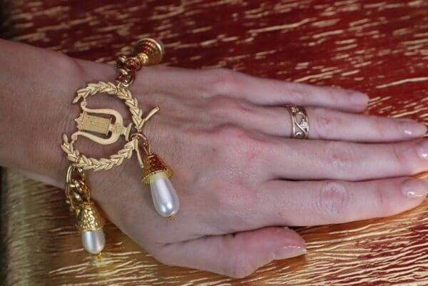 A woman 's hand with two rings and one bracelet.