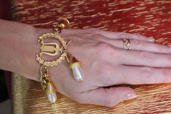 A woman 's hand with a ring and bracelet on her wrist.