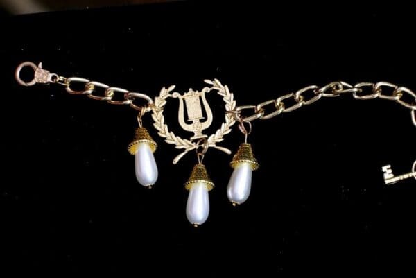 A chain with three pearls hanging from it.