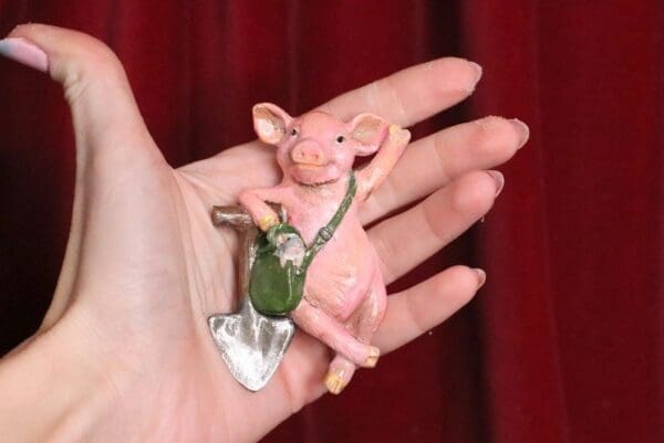 A pink pig is sitting on top of a silver key chain.