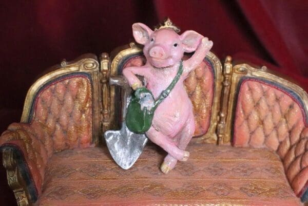 A pink pig with a purse on top of it.