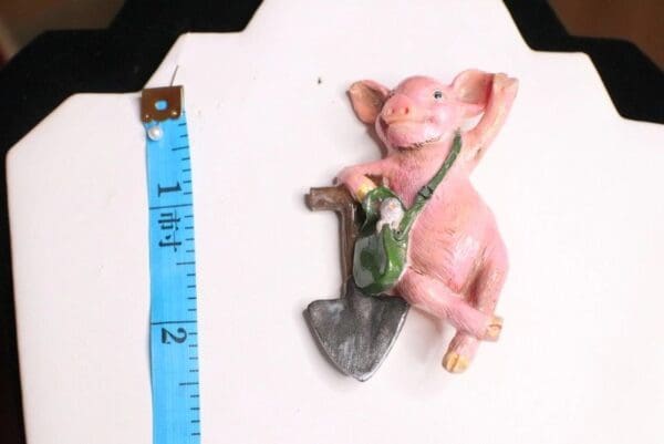 A pink pig with a shovel and ruler