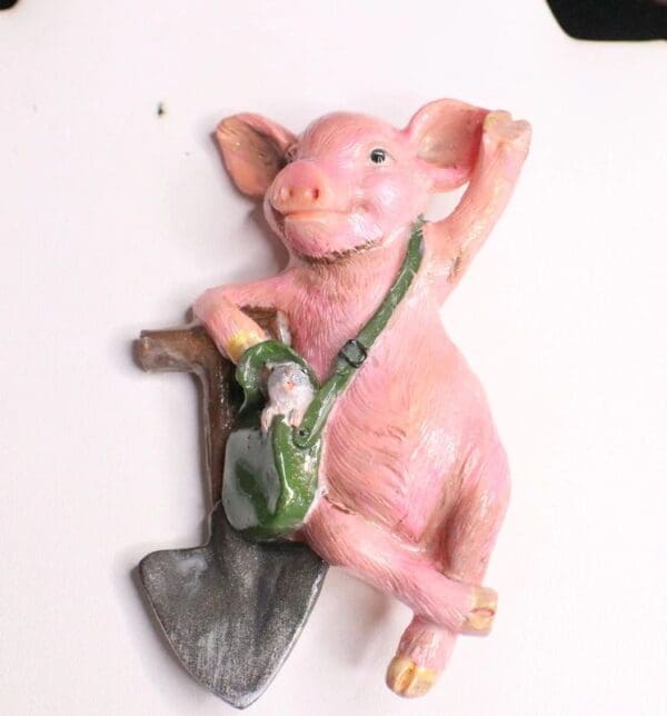 A pink pig with a green bag and an axe.