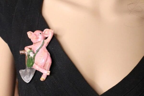 A close up of a person 's neck with a pink pig pin