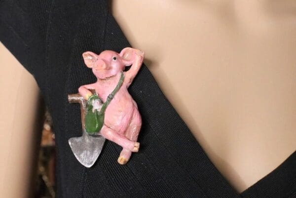 A pink pig holding a small axe and wearing a chain.