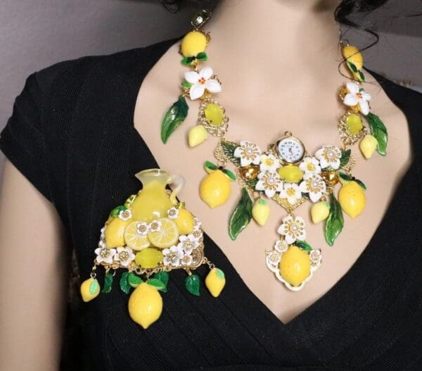 A woman wearing a necklace and earrings with lemons.