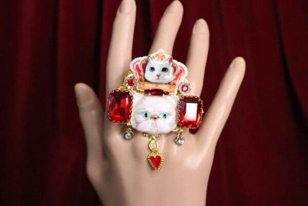 A hand with a ring on it and some jewels