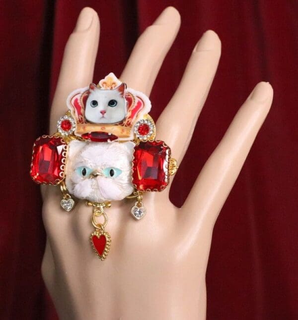 A hand with a ring on it and some kind of animal