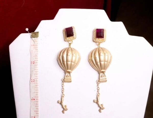 A pair of earrings with a cross hanging from the top.
