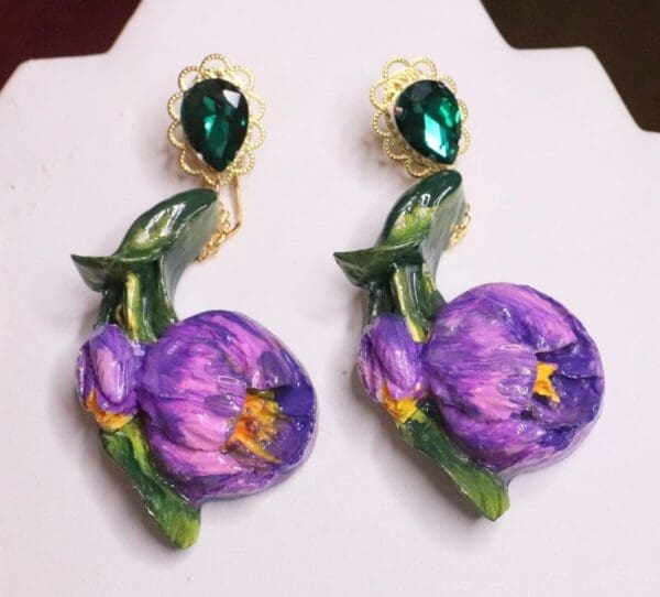 A pair of purple flowers with green leaves.