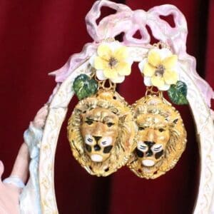 A pair of earrings with flowers and a lion head.