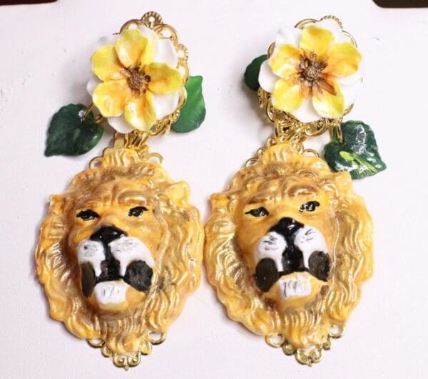 A pair of earrings with lions and flowers.