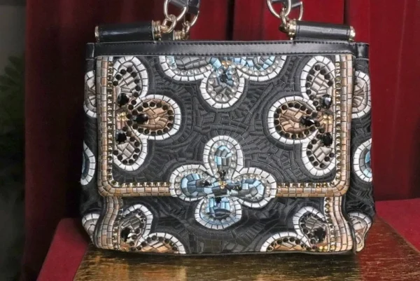 A purse with a chain handle and a mirror