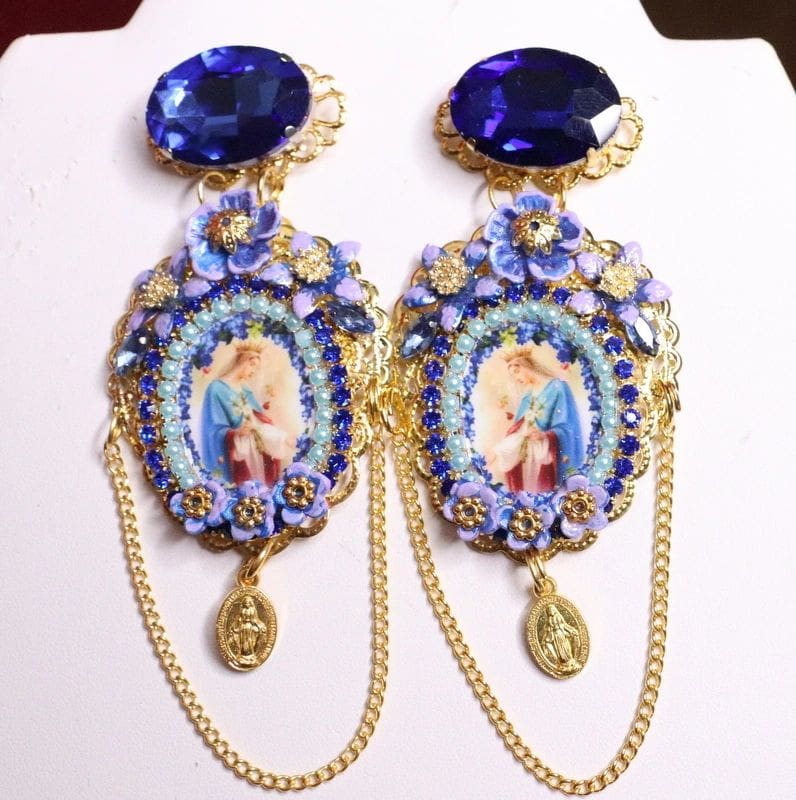 A pair of earrings with blue stones and a picture.
