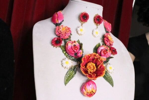 A white mannequin wearing a necklace and earrings.