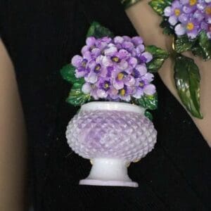 A close up of a person holding flowers in a vase