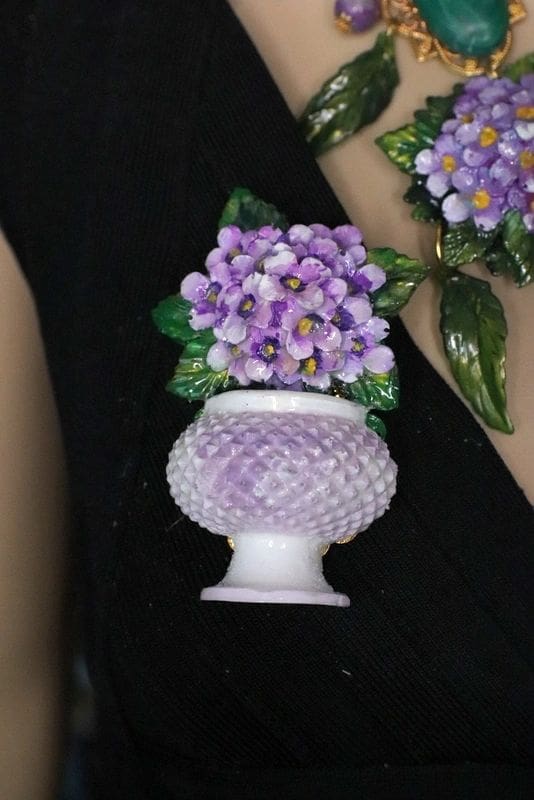A close up of a person holding flowers in a vase