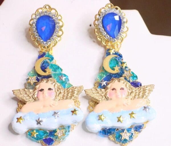 A pair of earrings with blue and gold decorations.