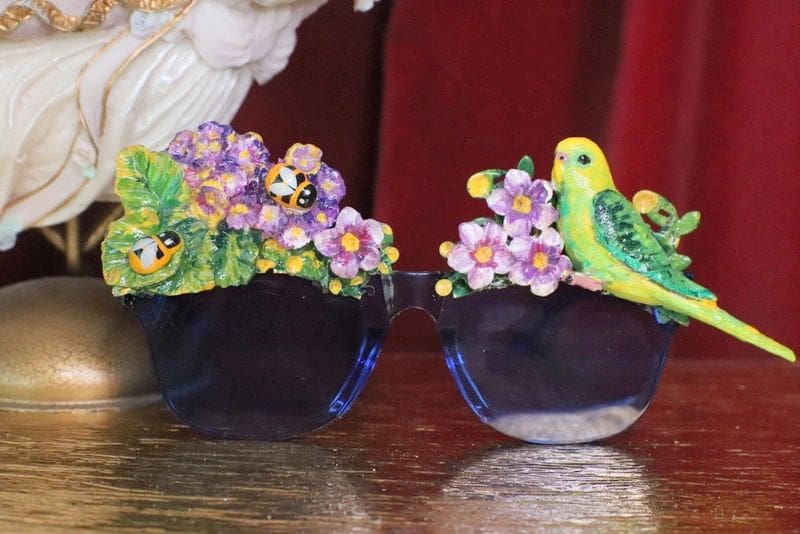 A pair of sunglasses with flowers and birds on them.