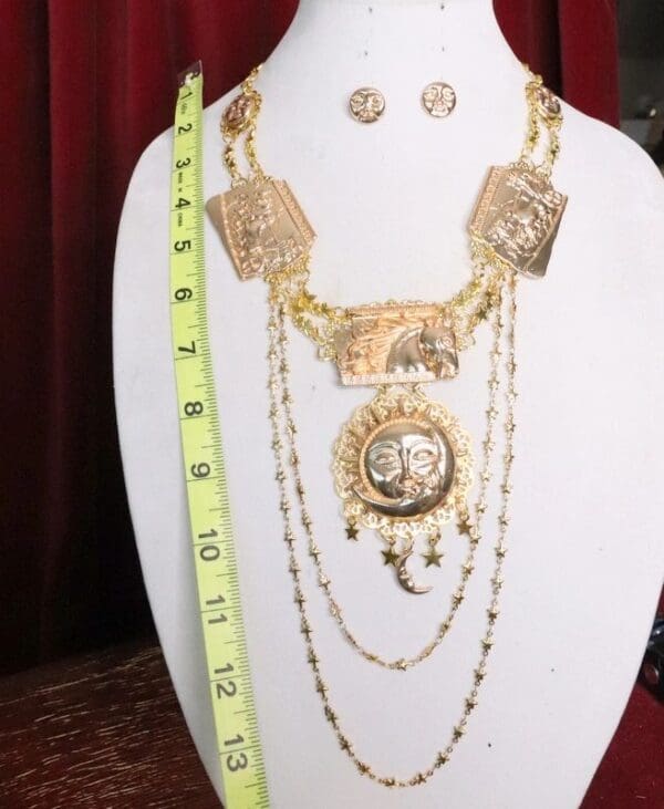 A necklace and earrings set on display in front of a measuring tape.