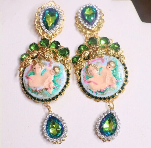 A pair of earrings with green stones and gold frame.
